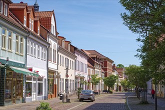 Residential and commercial buildings in Ernst-Thälmann-Straße, paved with cobblestones, in the old