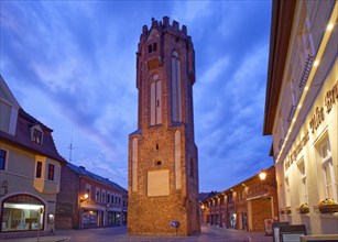 The brick Gothic Owl Tower, illuminated at night, in the old town centre of Tangermünde, Hanseatic