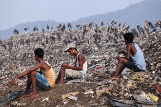 Ragpicker sitting next to a garbage-heap at Boragaon dumping site, on the eve of World Environment