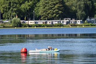 Lake Baldeney, Ruhrstausee, SUP as a reading island, young woman enjoying the summer, on her