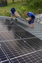 Installation of solar modules on the roof of a barn on a farm, over 240 photovoltaic modules are