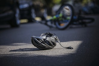 Symbol photo on the subject of bicycle accidents (posed scene) . A broken bicycle helmet lies next