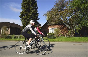 Landhaus, Niedersachsen, Reetdach, Radfahrer im Gang, Sport