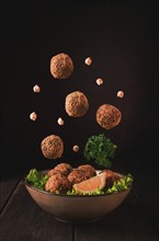 Chickpea falafel balls, on a wooden table, close-up, vegetarian food, levitation, vertical