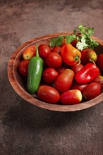 Set, cherry tomatoes, with colored peppers, in a wooden bowl, top view, no people