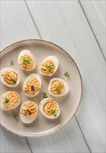 Boiled eggs stuffed with yolk with mayonnaise, on a white plate, selective focus, blurry, close-up,