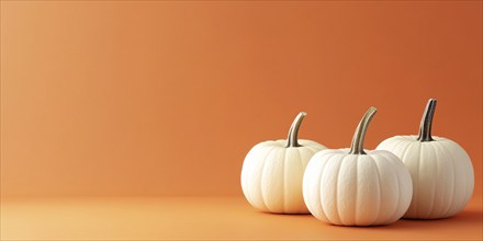 Three white pumpkins on orange background with copy space. Generative Ai, AI generated