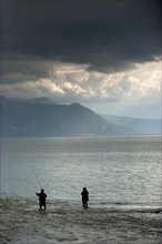 Angler in rainy weather against the light, weather, clouds, cloudy, fishing, hobby, fishing on the