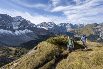 Two mountaineers on a hiking trail, mountain panorama with rocky steep peaks, view of summits