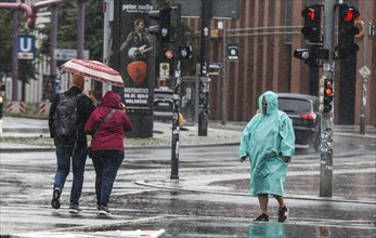 A man with a rain cape stands on a street in heavy rainfall, Berlin, 22/06/2024, Berlin, Berlin,