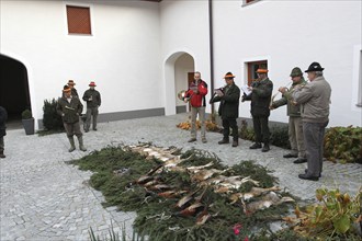 Hunters and hunting horn players blowing the shot hares (Lepus europaeus) and pheasants (Phasianus