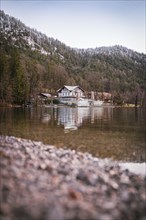 Tranquil lake scenery with house and reflection in front of a mountainous landscape, Der Seewirt,