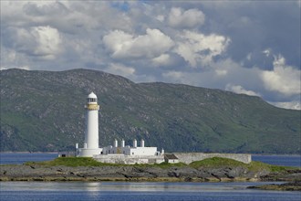 Lighthouse and building on an island, surrounded by the sea, under a cloudy sky, Lismore