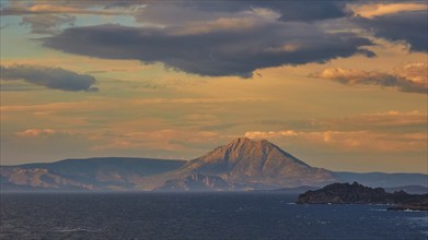 Sunset over the sea with mountain silhouettes and dramatic cloudy sky, Cape Melagkavi, Gulf of