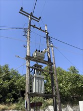 Power supply with electricity via electricity pylon with power cable and transformer in rural