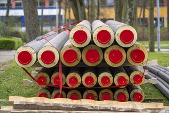 Pipe for district heating connections lying on a construction site on a stockpile, to be laid to