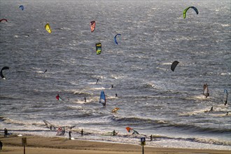 Kitesurfers and windsurfers in strong winds on the beach of Scheveningen, The Hague, Netherlands