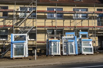 Energy-efficient refurbishment of residential buildings, older apartment block is scaffolded, gets