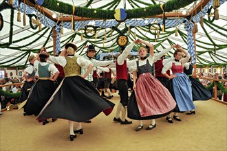 Dancers of a Bavarian folk dance group in traditional traditional costume dancing traditional