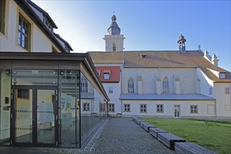 Gothic Wigberti Church and modern glass building with inner courtyard, stained glass windows,