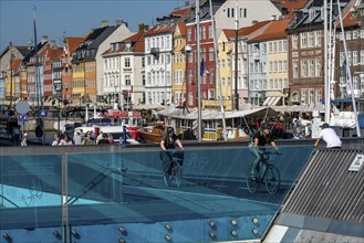 Cyclists on the Inderhavnsbroen cycle and footpath bridge, over the harbour, at Nyhavn, Copenhagen