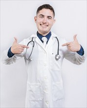 Satisfied young doctor pointing at himself on isolated background. Cheerful doctor pointing at