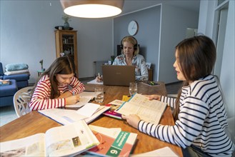 Homeschooling, during the lockdown in January 2021, children learn at home for school, their mum is