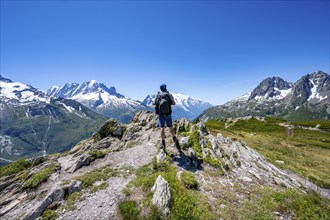 Mountaineer on hiking trail, mountain panorama with glaciated mountain peaks, Aiguille du Midi and