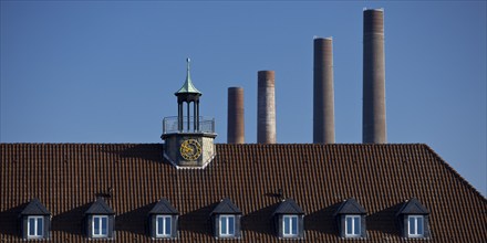 A house in Wolfsburg with the four chimneys of Volkswagen AG's old combined heat and power plant as