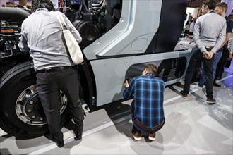 Visitors to the IAA Transportation trade fair take a look at a hydrogen combustion engine fuel