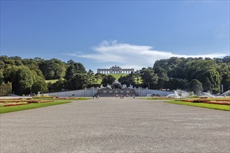 View of a large garden with a historic building in the distance and surrounded by greenery, Vienna