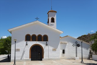 White church with bell tower under a clear blue sky with symbolic religious details, Nuestra Señora