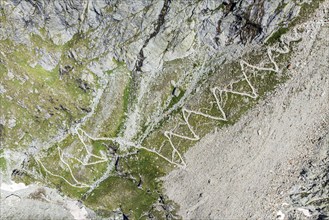 Serpentines of hiking trail up to mountain hut Cabane de Moiry, aerial view, Valais, Switzerland,