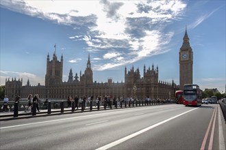 Big Ben and Palace of Westminster behind a bridge with buses and tourists, London, United Kingdom,