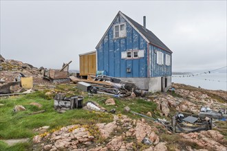 Blue-yellow wooden house, rubbish, scrap, Inuit settlement Ittoqqortoormiit, Scoresbysund or