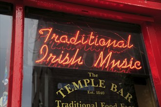 Neon sign for Traditional Irish Music in window of the Temple Bar pub, Dublin city centre, Ireland,