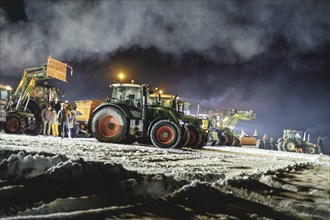 Tractors during a rally as part of the farmers' protests on the snow-covered Kirchbichl,