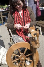 Woman demonstrating traditional spinning at a country craft event, Shottisham, Suffolk, England,