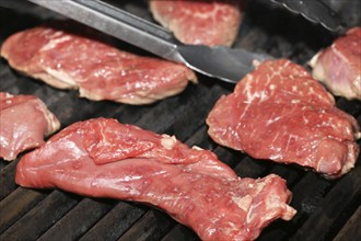 Raw steak on the grill