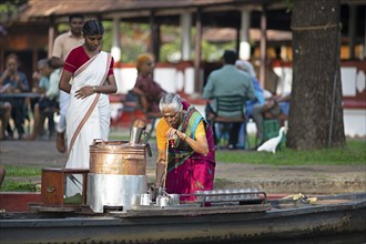 Tealady, 83 years old, making Indian tea on her boat, Backwaters, Kumarakom, Kerala, India, Asia