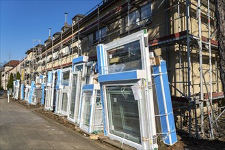 Energy-efficient refurbishment of residential buildings, older apartment block is scaffolded, gets