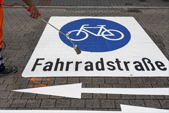 Application of road markings for a cycle lane, Rüttenscheider Straße in Essen, in the shopping and