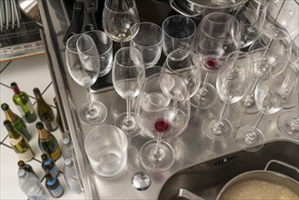 Kitchen after a big dinner, cooking party, dishes, dirty glasses, cooking utensils on the sink,