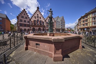 Fountain of Justice and Römer Town Hall on the Römerberg under a blue sky with cumulus clouds in