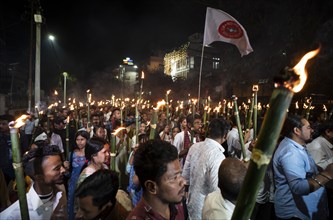 Members of the All Assam Students' Union (AASU) take part in a flaming torch rally and shout