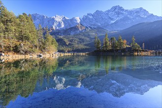 Steep mountains reflected in lake, evening light, autumn, Eibsee lake, Zugspitze, Bavaria, Germany,