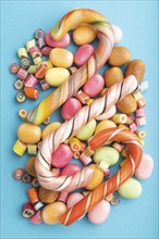 Various caramel candies on blue pastel background. close up, top view, flat lay