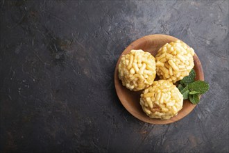 Traditional Tatar candy chak-chak made of dough and honey in wooden plate on a black concrete