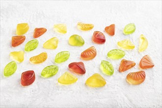 Various fruit jelly candies on gray concrete background. side view, close up