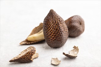 Salak or snake fruit on gray concrete background. Side view, close up, selective focus. Tropical,